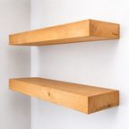 Two wooden shelves on a white wall