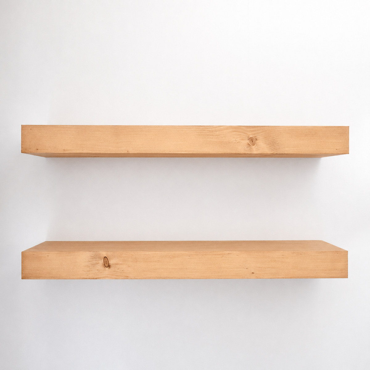 Two wooden shelves on a white wall