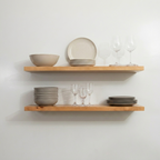 Wooden shelves with ceramic bowls and glasses against a white wall