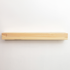 A minimalist, natural light wood floating fireplace mantel mounted on a plain white wall.