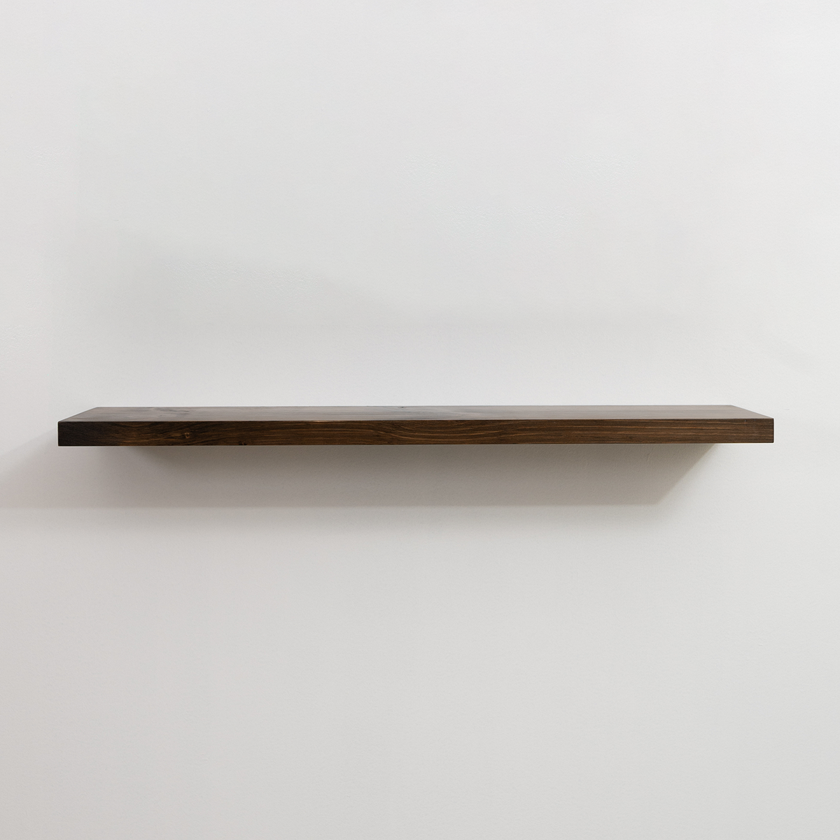 Wooden floating shelf on a white wall