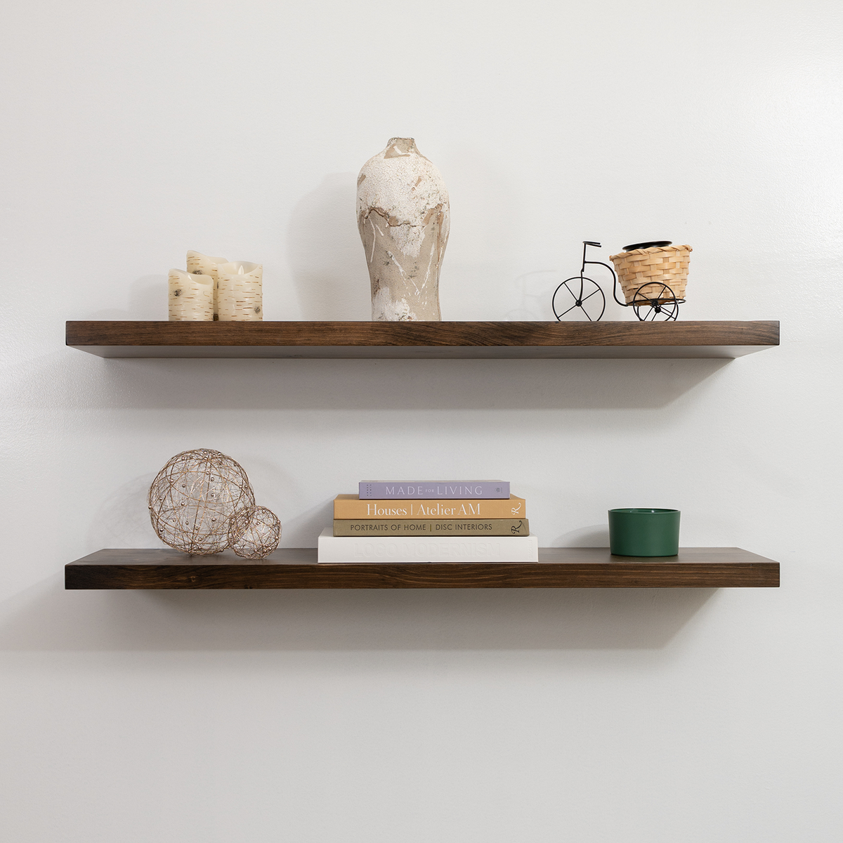 Two wooden shelves with decorative items against a white wall