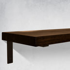 Close up of a Wooden Dark Brown Shelf with black supporting bracket on a light gray wall