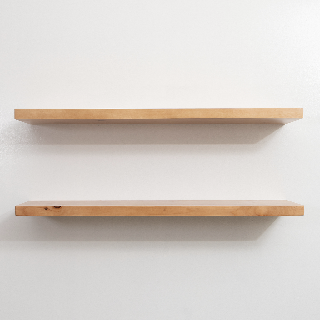 Two wooden shelves on a white wall