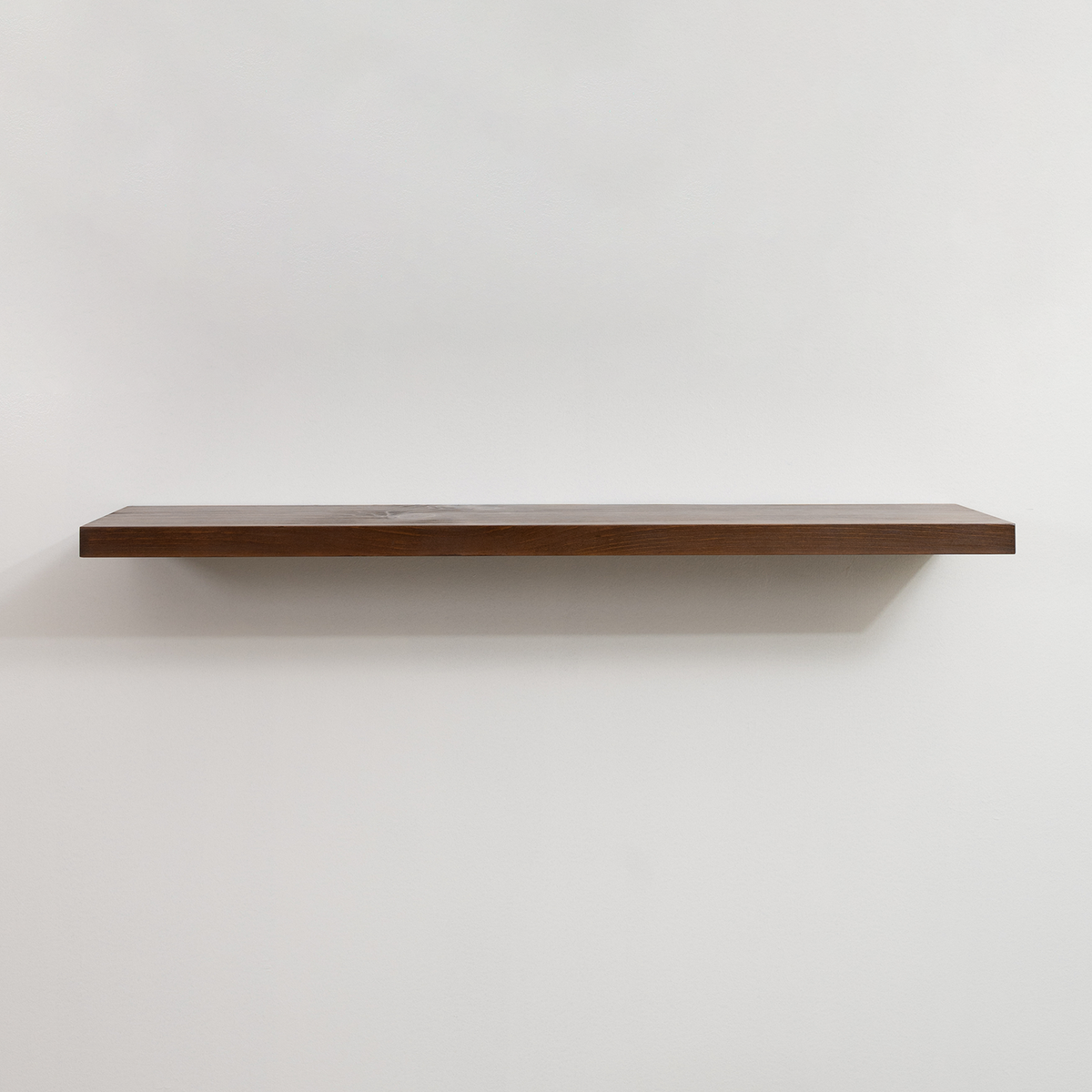 Wooden floating shelf on a white wall