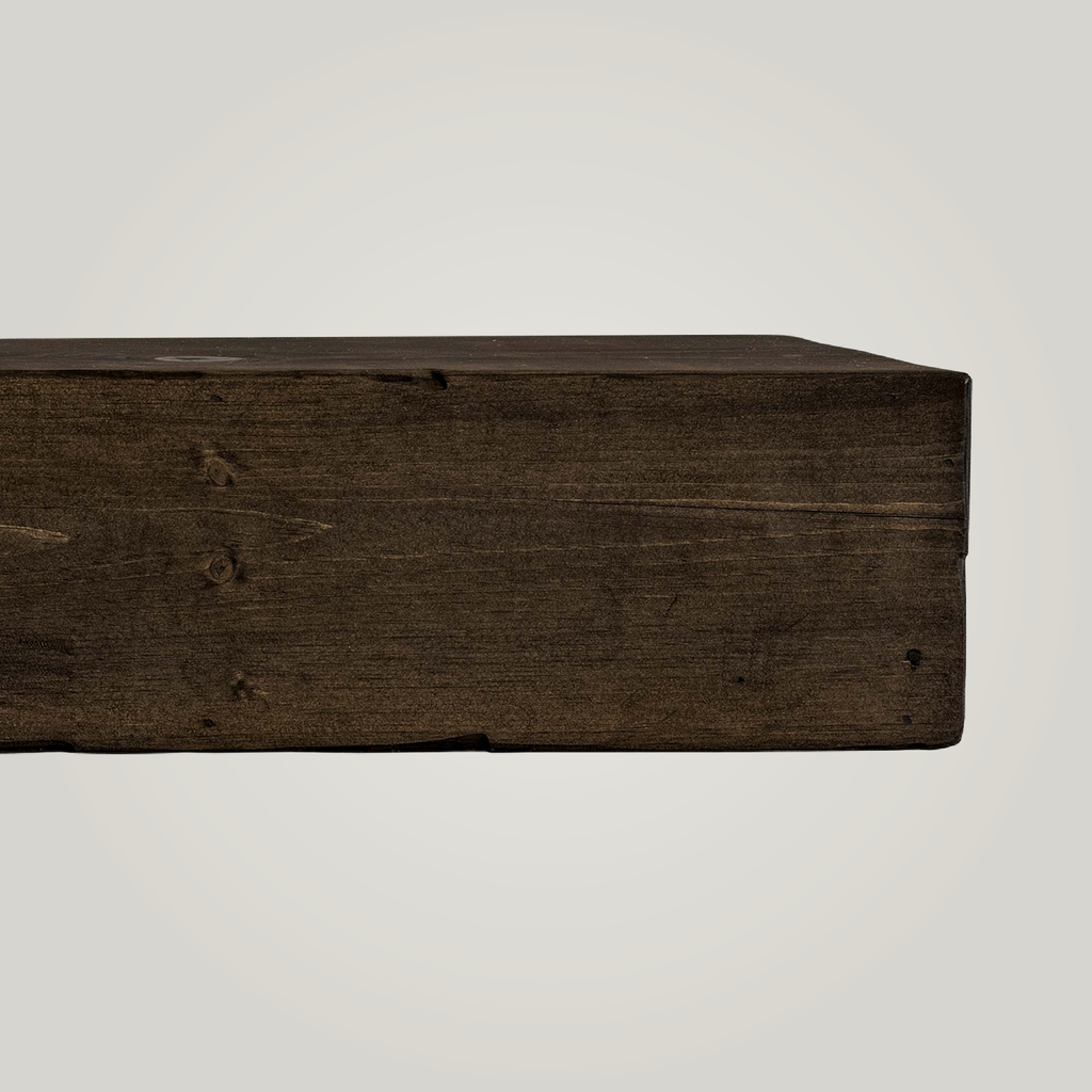 Dark brown rustic fireplace mantel on a light background