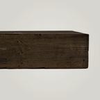 Dark brown rustic fireplace mantel on a light background