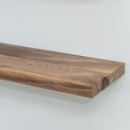 Wooden unfinished walnut floating shelf on a white background