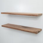 Two wooden unfinished walnut floating shelves on a white wall