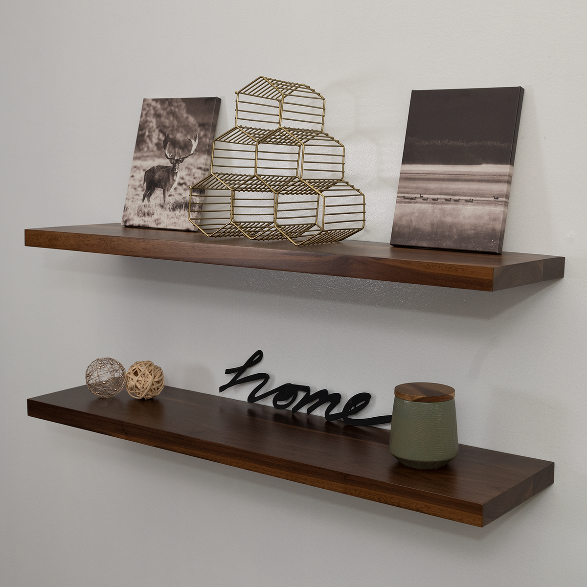 Two walnut wood floating shelves with decorations on a wall