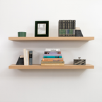 Wooden white oak unfinished floating shelves with books and decorative items against a white wall
