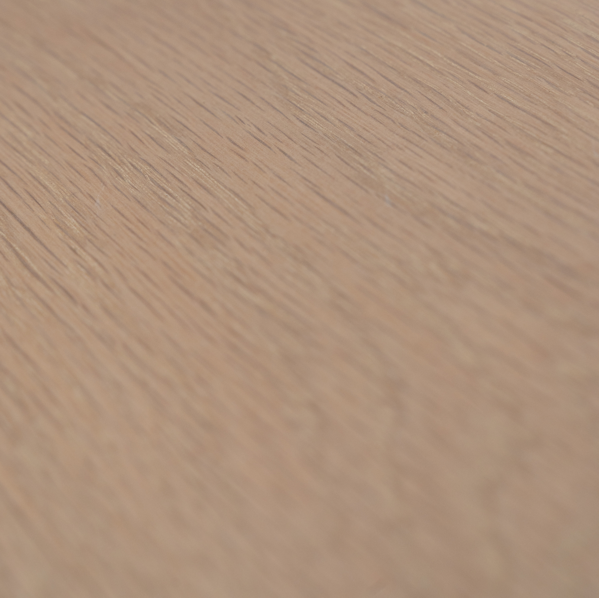 Close-up of a wooden white oak surface with a light brown color and visible grain pattern.