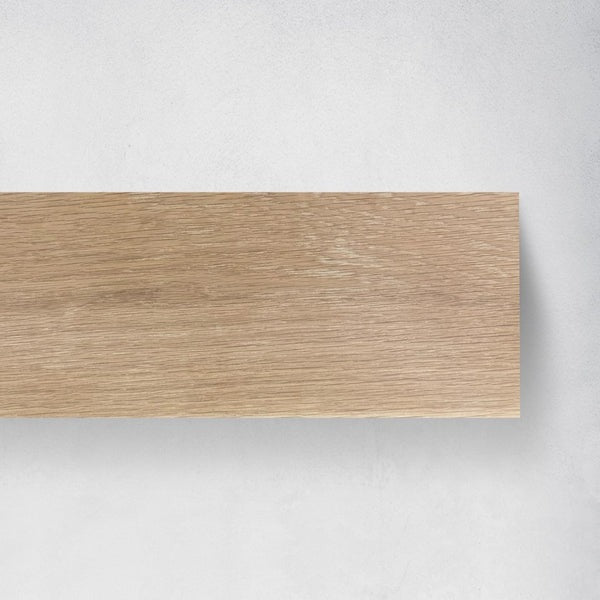 A rectangular wood fireplace mantel with a light oak grain pattern, shown against a neutral light gray textured background.
