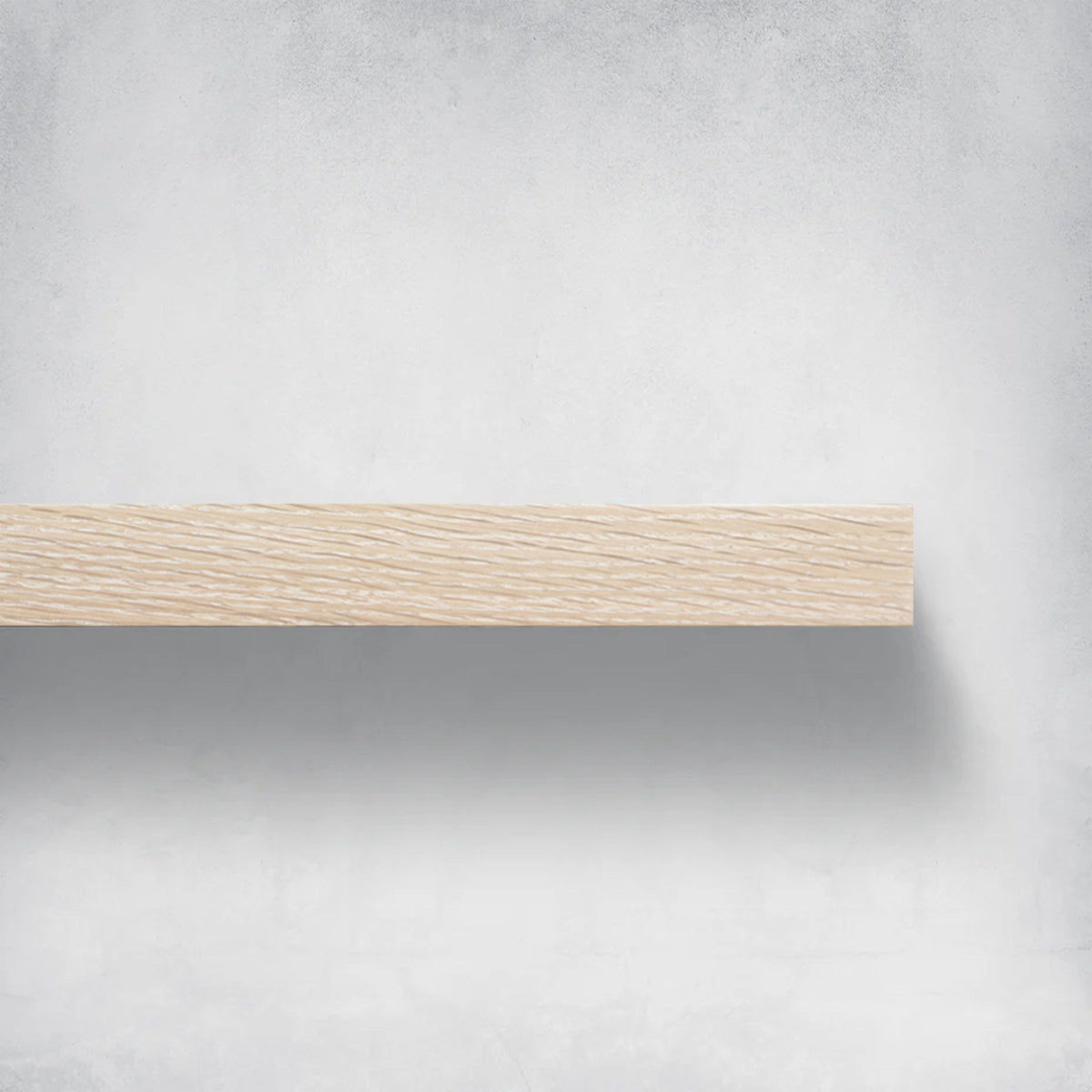 White oak floating shelves installed on a wall, holding various household items like dishes, books, and decorative objects.